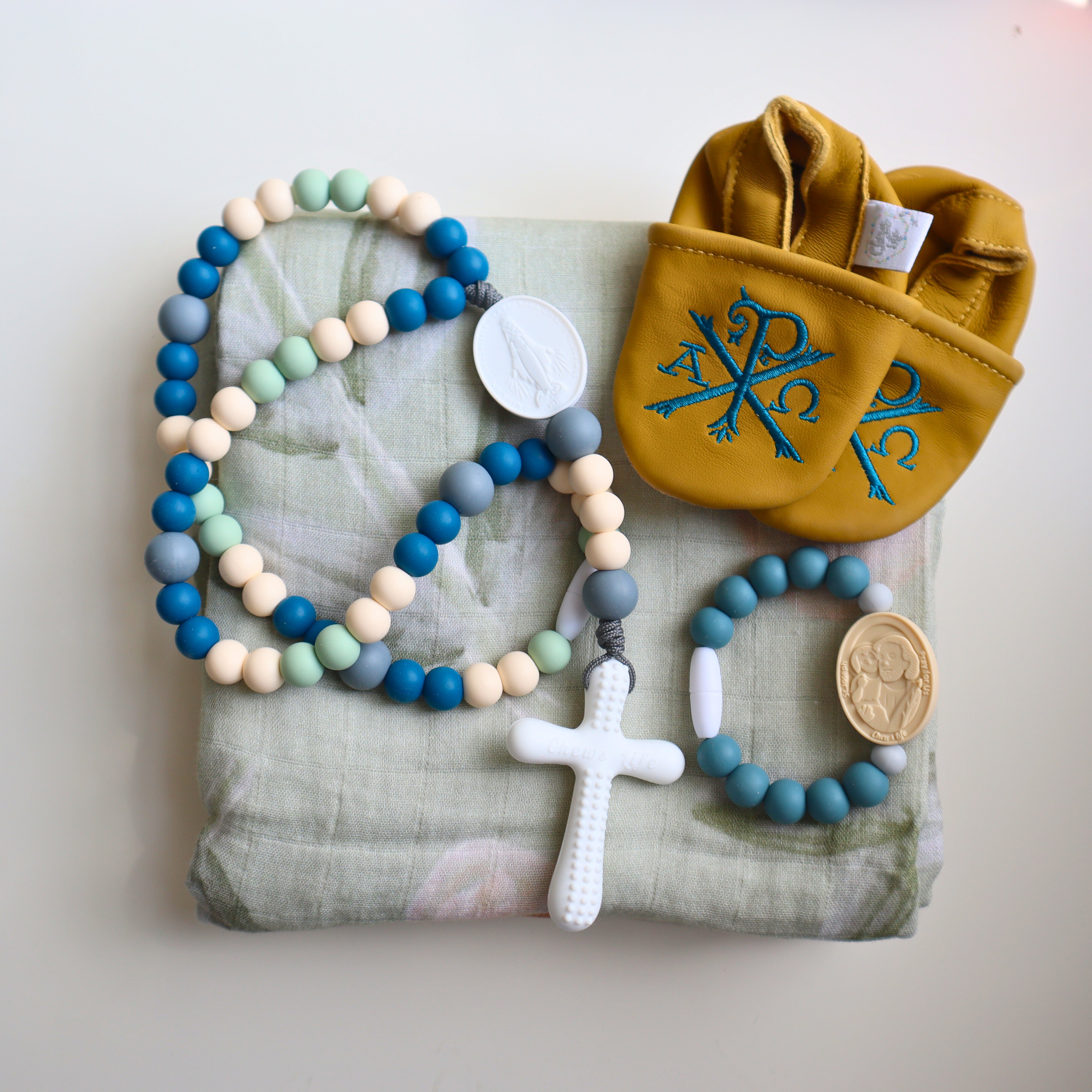 Deluxe Baby Gift Set | Silicone Rosary & Saint Bracelet, Swaddle & Emmaus Crib Shoes