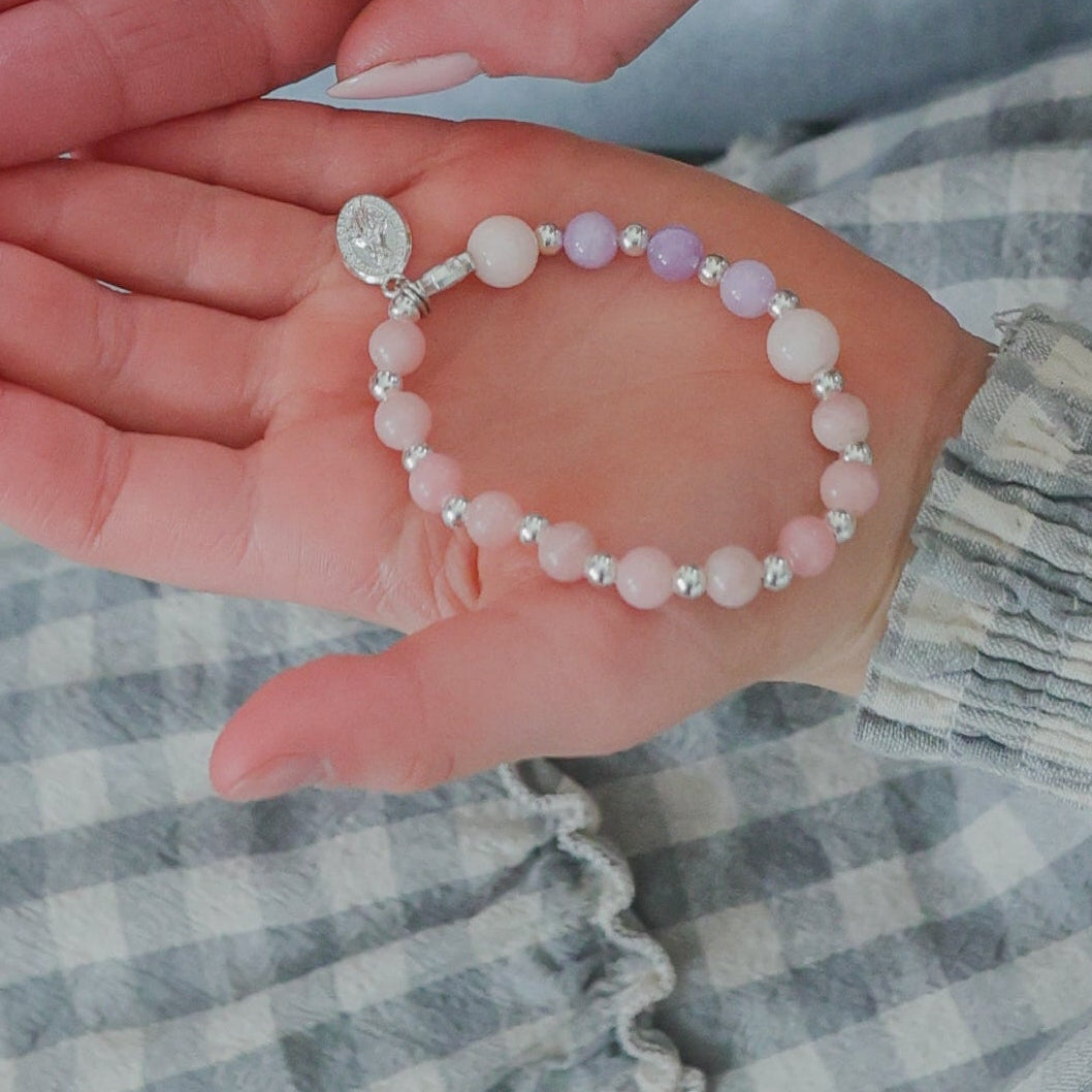 Woman and child holding pink bracelets together